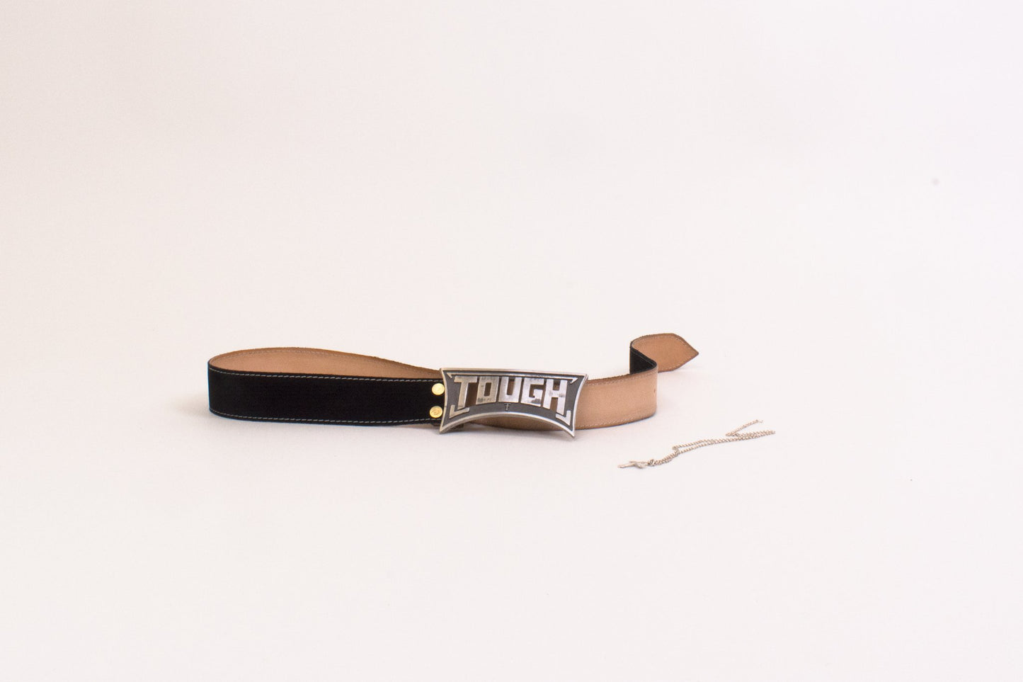Leather belt with 'TOUGH' branding on a beige background