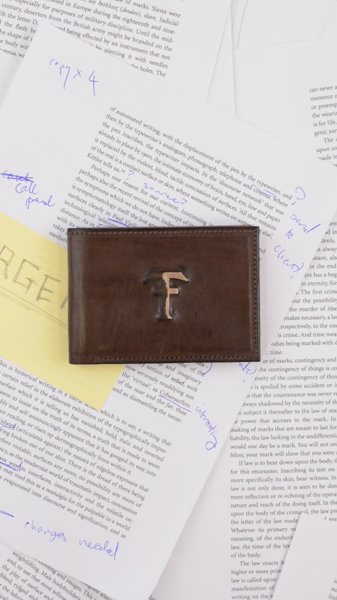 Brown leather wallet with a gold emblem on top of a newspaper
