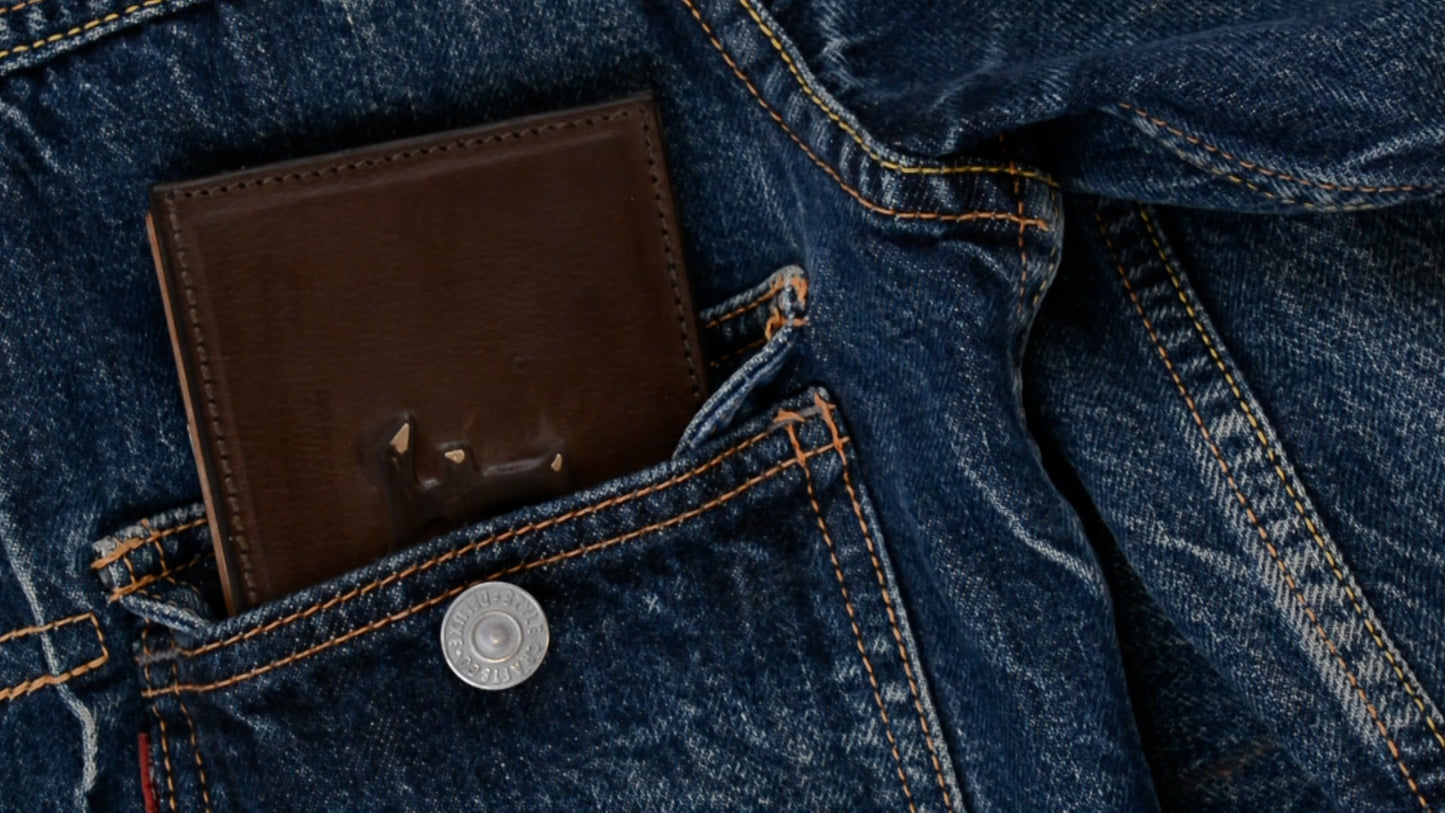 Brown leather wallet in a blue denim pocket